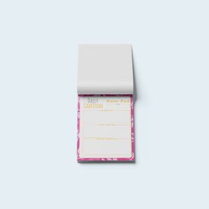 Mockup of a daily gratitude notepad with a pink border, featuring prompts for gratitude, daily learnings, and moments of joy on a white background.